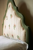 Pink flower motif on upholstered bedhead on single bed
