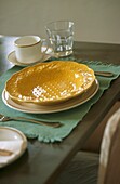 Place setting with decorative yellow china plate