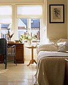 Light and airy bedroom in an Edwardian house with a mixture of new and old furniture