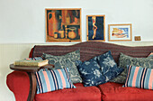 Rotes Sofa in einem mit Kissen bedeckten Wohnzimmer