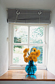 Yellow Gerbera flower display on window sill in a bedroom
