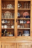 Wooden kitchen dresser displaying tableware on open shelving