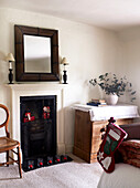 Bedroom fireplace with christmas presents in grate and red candles on the hearth
