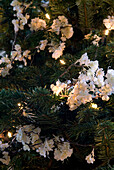 White blossom and fairylights on pine Christmas tree
