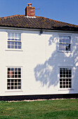 Weiß getünchte Außenfassade eines Kirchengebäudes aus den 1850er Jahren in Suffolk mit Sprossenfenstern