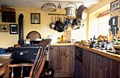 Wooden tongue and groove kitchen units painted in wood stain with a Windsor chair 