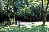 Ruderboot in einem Garten in Suffolk am Flussufer festgemacht