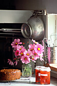 Collander hangs above pink flower arrangement in country kitchen