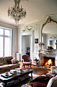 Gilt framed mirror above fireplace in French apartment living room