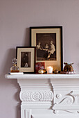 A homemade ceramic Christmas pudding joins baubles tea-lights and old family photographs on the bedroom mantelpiece