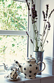 Teekannen und Lavendel auf der Fensterbank