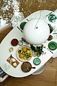 Elevated view of white pendant light and dining table set with green crockery