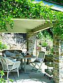 Breakfast on table of shaded garden terrace