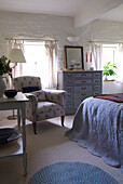 Floral gemusterter Sessel in einem Schlafzimmer mit niedriger Decke