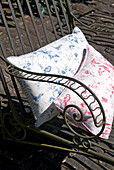 Cushions in contrasting colours on metalwork chair