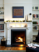 Lit fire in a living room decorated for Christmas