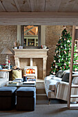 Weihnachtsbaum und Holzofen in einem Bauernhaus in Wiltshire