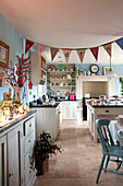 Bunting hangs in pastel blue country style kitchen
