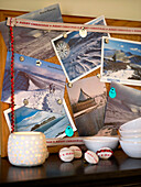 Lit candle and buttons with pin board of winter scenes