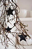 Silver baubles and star shaped decorations on pine branch in London home