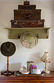 Brown suitcases and vintage hats with tea tray in Devon home