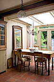 Candelabra hangs above dining table in Devon kitchen conservatory