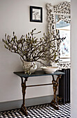 Monochrome hallway with display of blossom on a console table