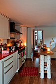 Red and white country style kitchen in London home UK