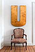 Re-upholstered chair under oversized letter U in modern Odense family home Denmark