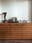 Digital radio and ornaments with statue on retro wooden sideboard in Suffolk home England UK
