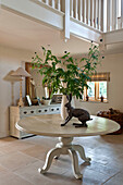 Metal hare statue on pedestal base table with leaf arrangement in entrance hallway of Canterbury home England UK