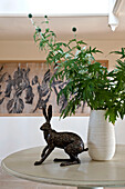 Metal hare statue with leaf arrangement and artwork in entrance hallway of Canterbury home England UK