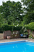 Bench seat at corner of walled swimming pool Canterbury home England UK