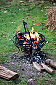Burning logs in wrought iron garden stove Yeovil Somerset, England, UK