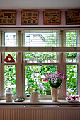 Schnittblumen auf der Fensterbank mit Blick auf den Garten London home UK