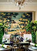 Dining table and chairs with artwork and place settings in West London townhouse England UK