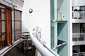 Table and chairs on decked balcony exterior of London apartment England UK