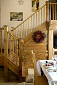 Wooden staircase in open plan dining room of rural Suffolk home England UK
