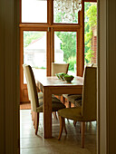 Wooden dining table with upholstered chairs in rural Suffolk home England UK