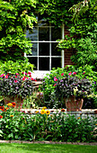 Fenster und Garten eines Landhauses aus Backstein in Suffolk, England, UK