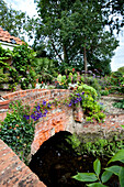 Brick footbridge in rural garden exterior of Suffolk country house England UK