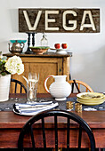 Table ware and sign reading 'vega' in country styled London home, UK