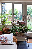 Korb mit Stechpalmen und Vogelornamenten am Fenster des Hauses in Walberton, West Sussex, England, UK