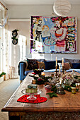 Christmas ornaments on low wooden table with large modern art canvas in living room of Forest Row home, Sussex, England, UK