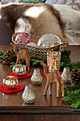 Wooden camels and tealight holders with glass baubles on table in Forest Row home, Sussex, England, UK