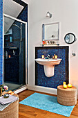 Mit blauem Mosaik gefliestes Badezimmer und Duschkabine in einem Familienhaus in Forest Row, Sussex, England, UK