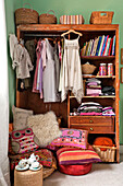 Dresses, floor cushions and wardrobe in girls room of Forest Row family home, Sussex, England, UK