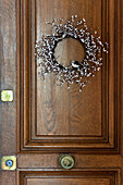Floral wreath with birds on wooden front door of Paris Apartment, France