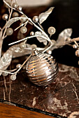 Silver bauble and sprig of berries in Paris apartment, France