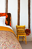 Retro fabric on headboard of bed in timber framed Hertfordshire home, England, UK